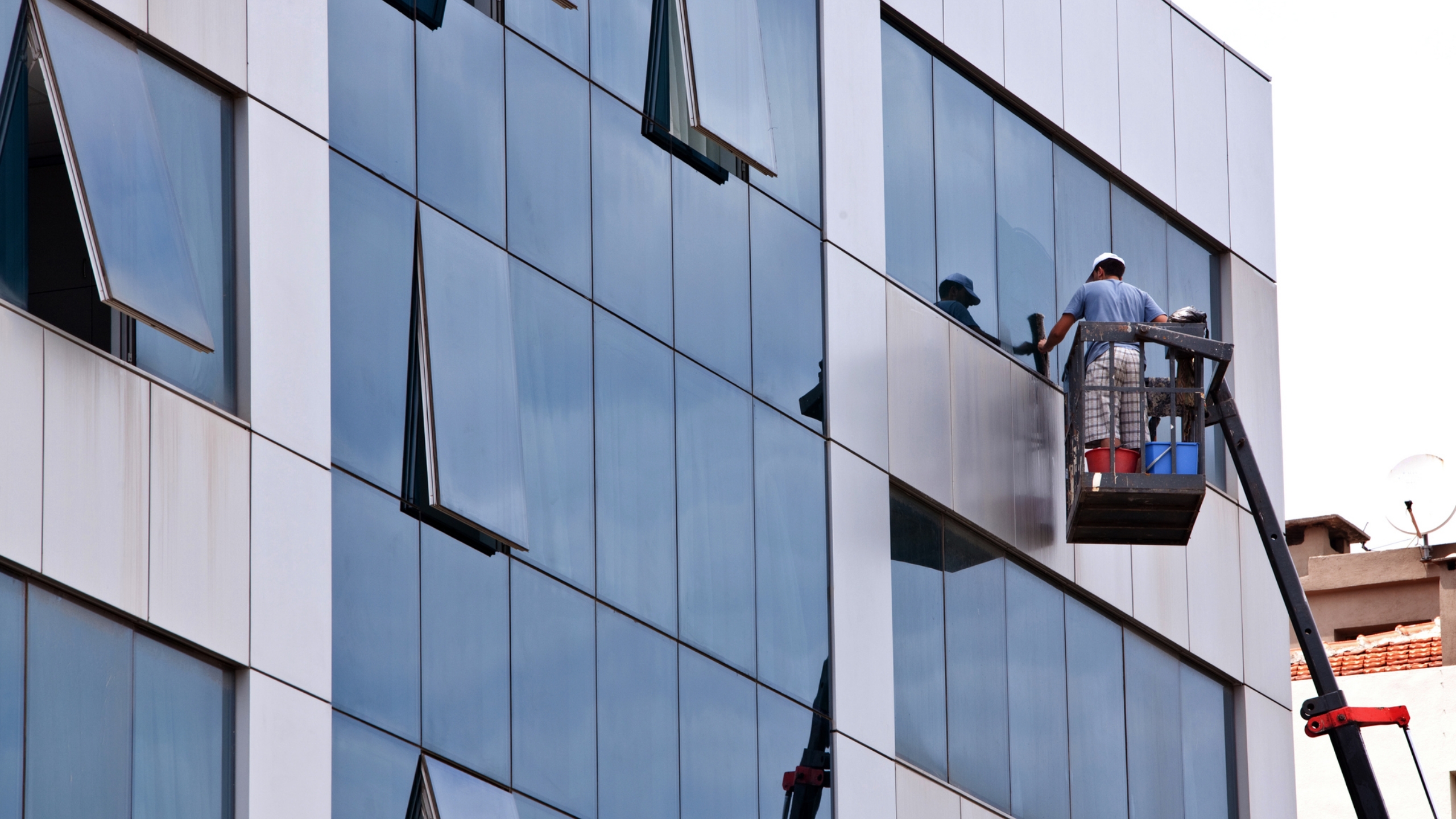 Fassaden- und Fensterreiniger der SWD Gebäudereinigung München bei der professionellen Außenfensterreinigung eines mehrstöckigen Gebäudes – streifenfreie Sauberkeit für klare Sicht und gepflegten Eindruck.